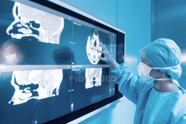Chirurg sucht Magnetresonanztomographie (MRT) Gehirnscans während einer Gehirnoperation. — Stockfoto
