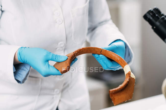 Archaeologist reconstructing broken pottery in laboratory. — Stock Photo