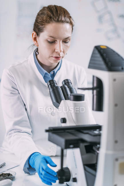 Portrait of young female archaeologist working with microscope. — Stock Photo