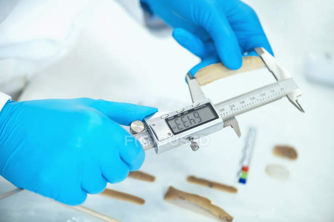 Archaeologist measuring lithics with caliper in laboratory. — Stock Photo