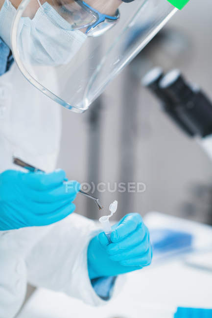 Cientista feminina segurando micro tubo com amostra em laboratório de DNA antigo . — Fotografia de Stock