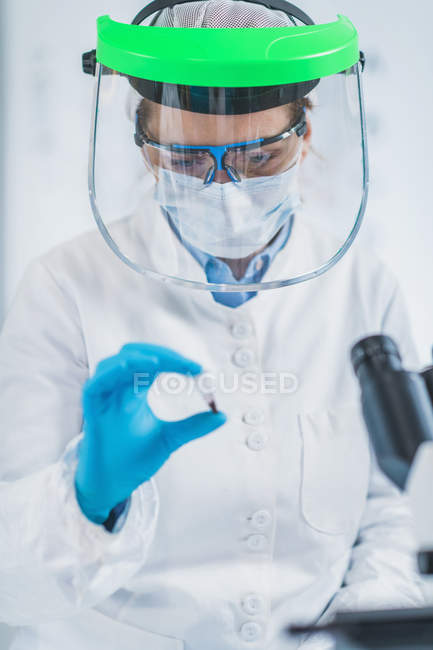 Жіночий біоархеолог аналізує мікро трубку з людським остеологічним матеріалом у лабораторії.. — стокове фото