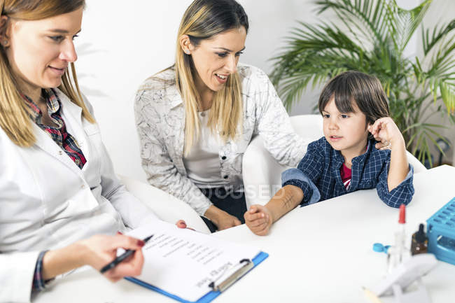 Pediatra femminile che esegue test di puntura della pelle allergica su bambino con madre nell'ufficio immunologo . — Foto stock