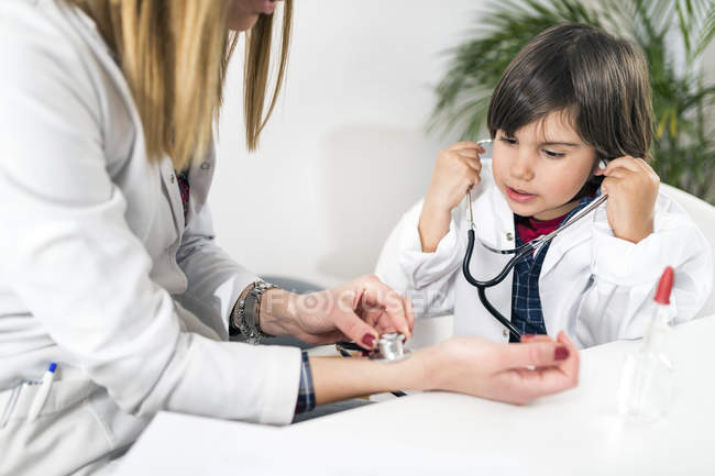 Little boy using stethoscope as playing at being doctor in pediatrician office. — Stock Photo