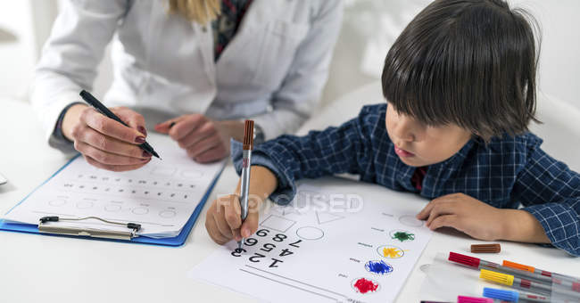 Preschooler boy undergoing logic test with numbers for developmental psychology test in female psychologist office. — Stock Photo