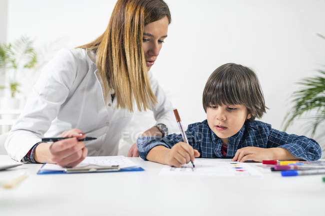 Маленький мальчик проходит логический тест с номерами для теста по психологии развития в офисе женщины-психолога . — стоковое фото