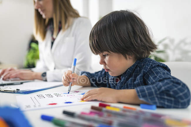 Vorschulkinder färben Formen mit bunten Kugelschreibern für entwicklungspsychologischen Test im Psychologenbüro. — Stockfoto