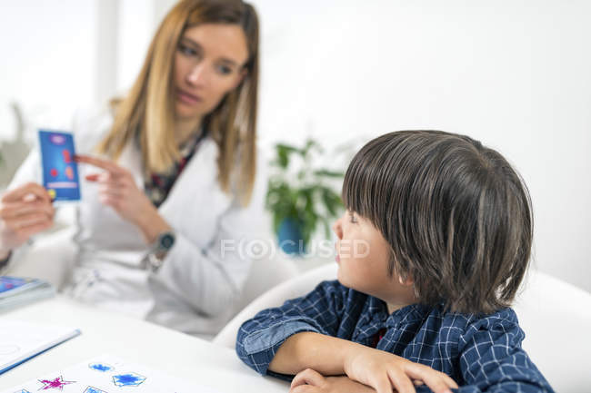 Preschooler boy undergoing logic cards test for developmental psychology test in female psychologist office. — Stock Photo