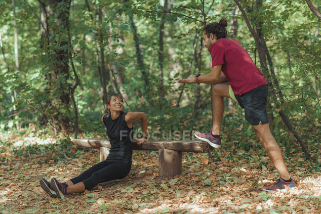 Frau macht Liegestütze im Park mit Personal Trainer. — Stockfoto