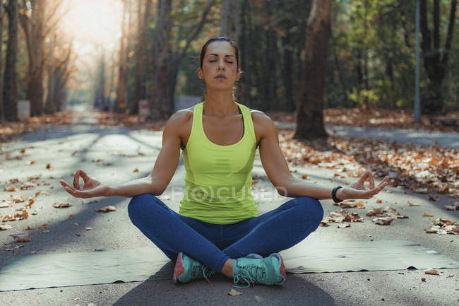 Woman meditating with hands in mudra as doing yoga in autumn park. — Stock Photo
