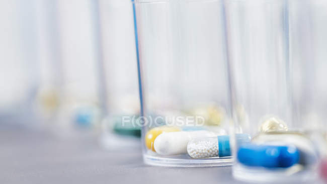 Variété de pilules pharmacologiques dans des gobelets jetables en plastique, concept de médicament . — Photo de stock