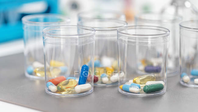 Різноманітність фармакологічних таблеток в одноразових пластикових чашках, поняття ліків. — стокове фото