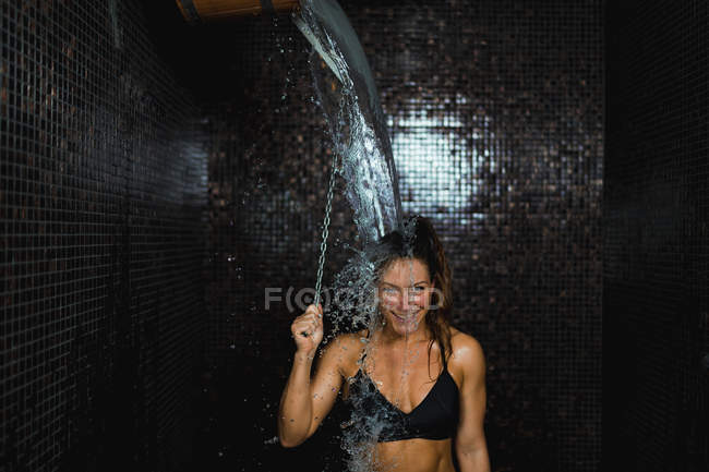 Жінка має відро з холодним душем після сауни . — стокове фото