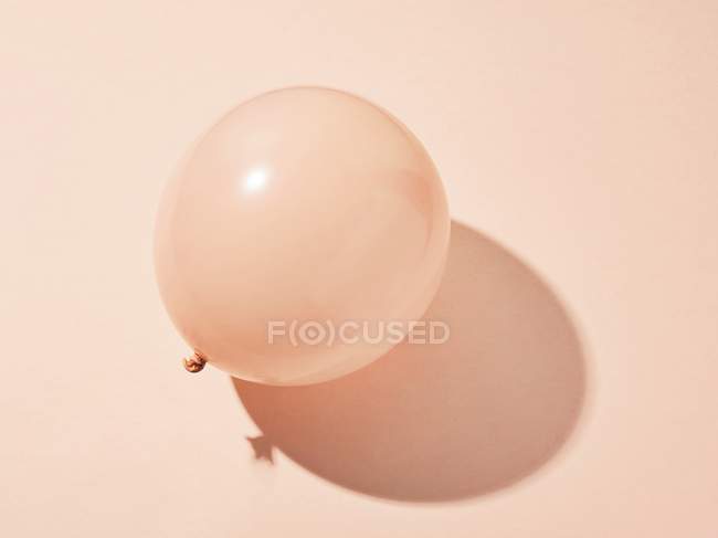 Beiger Ballon auf glattem Hintergrund mit Schatten, Studioaufnahme. — Stockfoto
