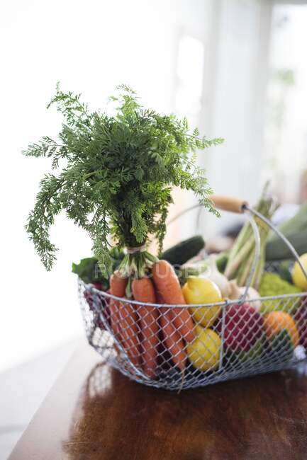 Cesta de verduras frescas, zanahorias, limones, ajo, espárragos, rábanos y tomates.. - foto de stock