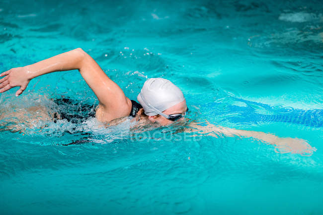 Mulher desportiva nadando na água da piscina . — Fotografia de Stock