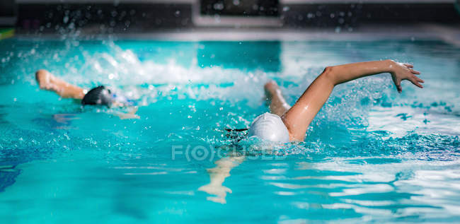 Mulheres aptas a nadar juntas na piscina interior . — Fotografia de Stock