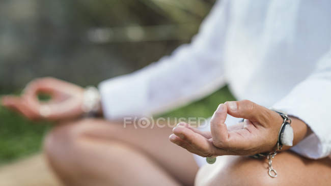 Cierre de las manos en el murmullo de la mujer que medita y equilibra la energía. - foto de stock