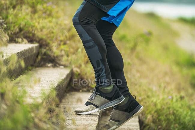 Sección baja del hombre haciendo ejercicio escaleras al aire libre . - foto de stock