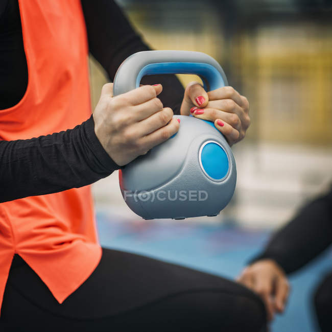Mani di donna sportiva sollevamento kettlebell durante l'allenamento all'aperto . — Foto stock