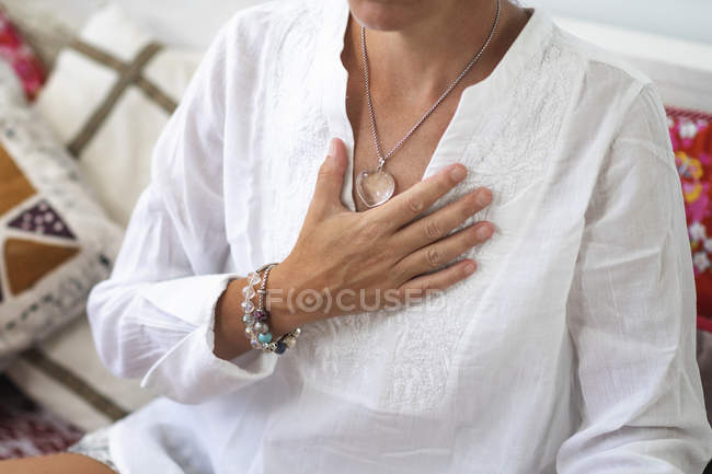 Woman with right hand on heart chakra, spiritual awakening. — Stock Photo
