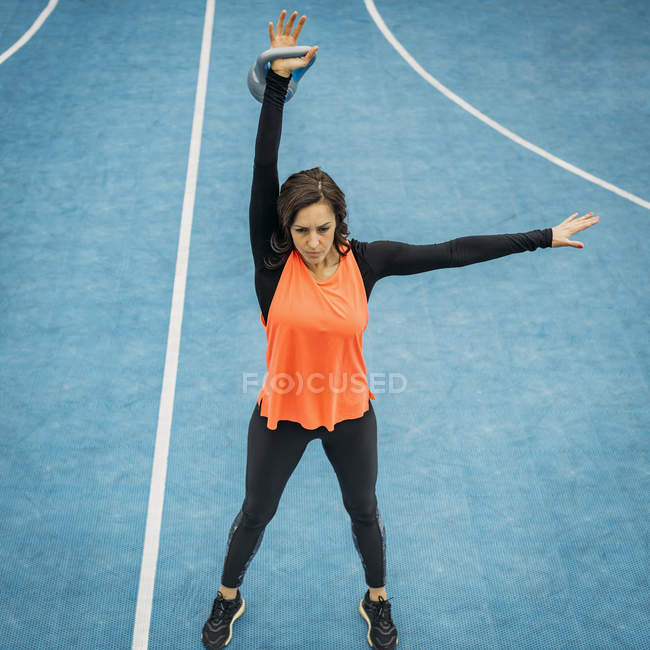 Giovane donna sportiva sollevamento kettlebell in classe fitness all'aperto . — Foto stock