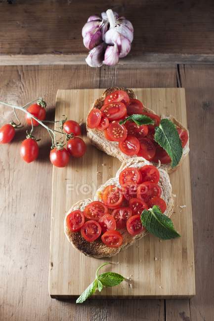 Bruschetta Italian toasted bread topped with cut fresh tomatoes. — Stock Photo