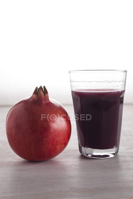 Frischer Granatapfel und ein Glas Granatapfelsaft. — Stockfoto