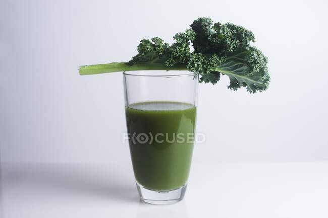 Green juice made of kale and a fresh kale leaf. — Stock Photo