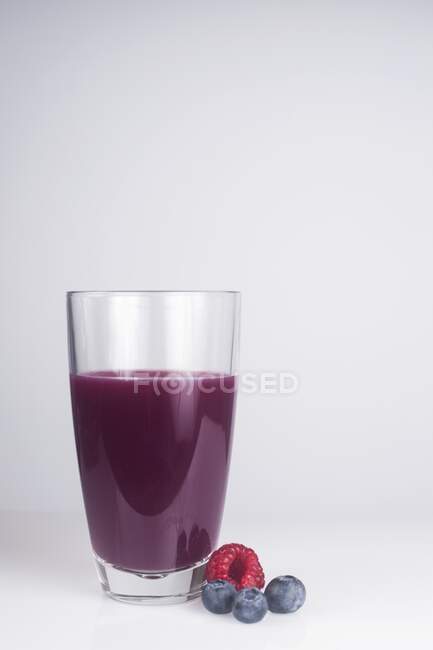 Bicchiere di succo fresco fatto con frutti di bosco misti . — Foto stock