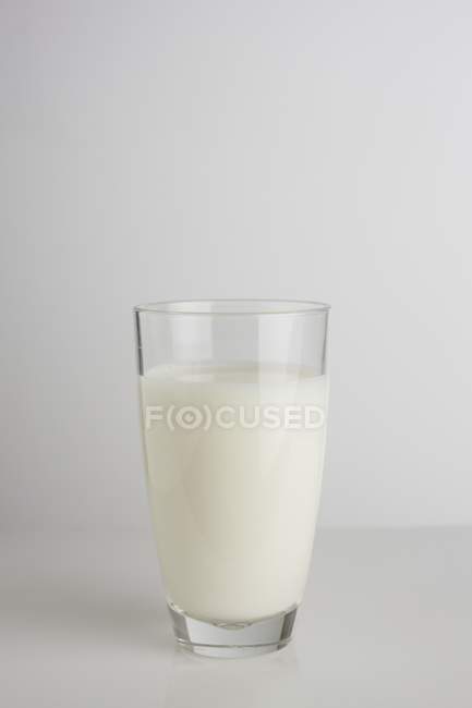 Glass of fresh dairy milk on plain background, studio shot. — Stock Photo