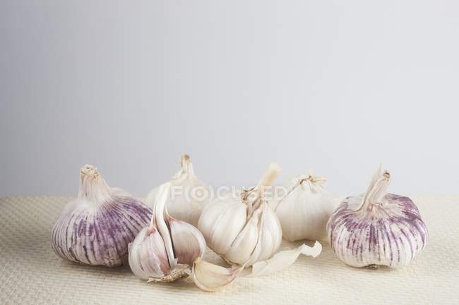 Bulbos de ajo sobre la mesa sobre fondo blanco . - foto de stock
