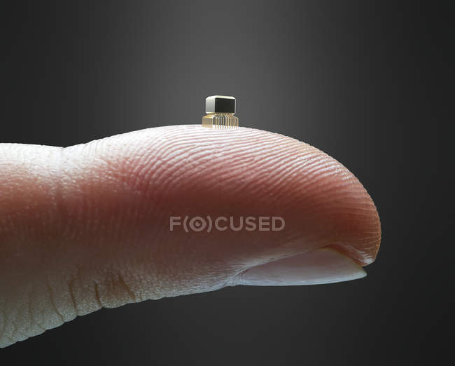 Finger holding miniaturized microchip on fingertip, digital illustration. — Stock Photo