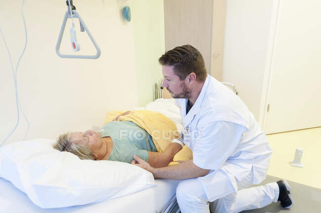 Geriatric hospital ward. Nurse helping a confused patient on the geriatric ward of a hospital. — Stock Photo