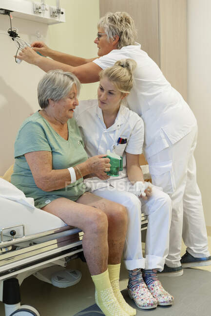 Госпиталь Гериатрии. Медсестры помогают запутавшемуся пациенту в старом отделении больницы. — стоковое фото