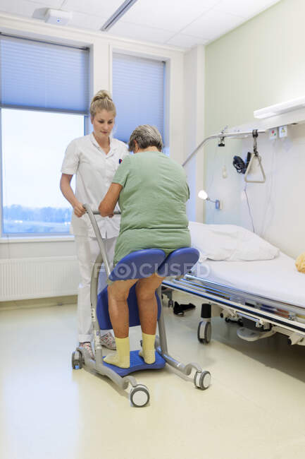 Geriatrische Krankenstation. Krankenschwester hilft einem verwirrten Patienten auf der geriatrischen Station eines Krankenhauses. — Stockfoto