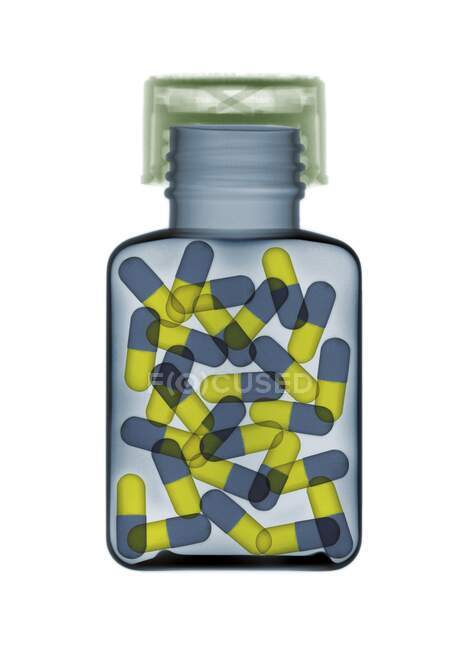 Pilules bleues et jaunes en flacon, rayons X colorés. — Photo de stock