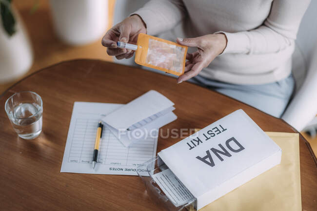 Femme âgée préparant le kit de test ADN. — Photo de stock