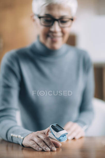 Using pulse oximeter at home to test oxygen level in blood. — Stock Photo