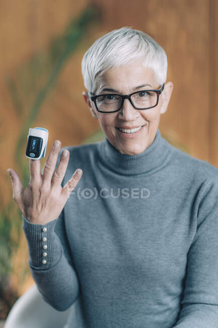 Using pulse oximeter at home to test oxygen level in blood. — Stock Photo