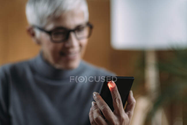 Senior mulher medir pulso ou frequência cardíaca com telefone inteligente . — Fotografia de Stock