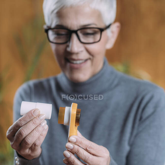Femme âgée utilisant un spiromètre, mesurant la capacité pulmonaire et la force expiratoire maximale. — Photo de stock