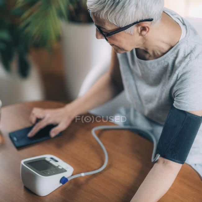 Saúde móvel. Medição da pressão arterial e entrada de dados no telefone inteligente . — Fotografia de Stock