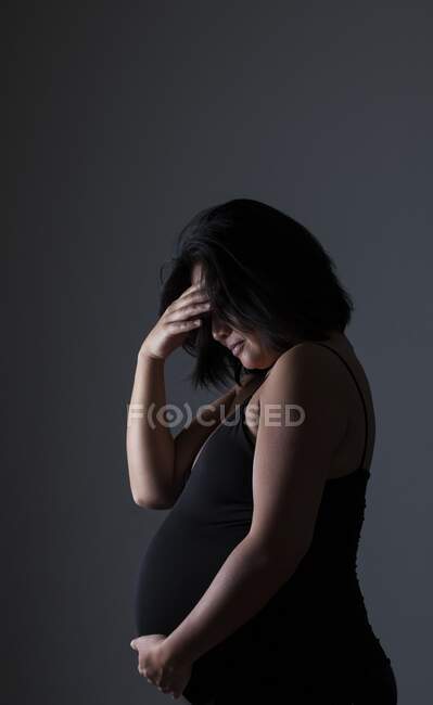 Schwangere und traurige Frau bedeckt Gesicht — Stockfoto
