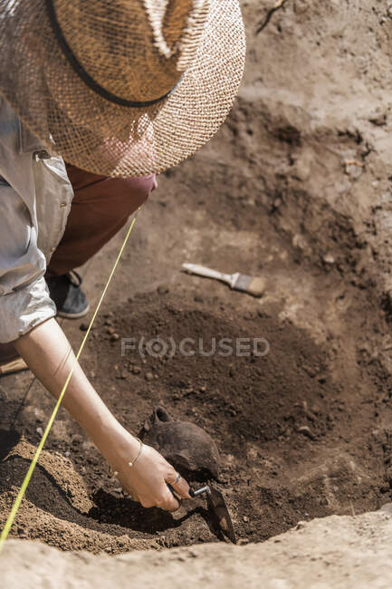 Archéologue creuser avec une truelle à la main, récupérer de la poterie à partir d'un site archéologique. — Photo de stock