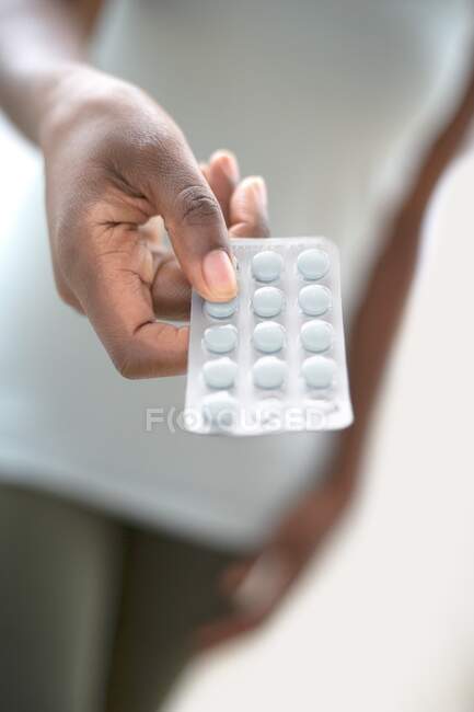 Femme offrant blister paquet de pilules. — Photo de stock