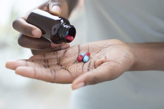 Жінка вливає таблетки в її руку . — стокове фото