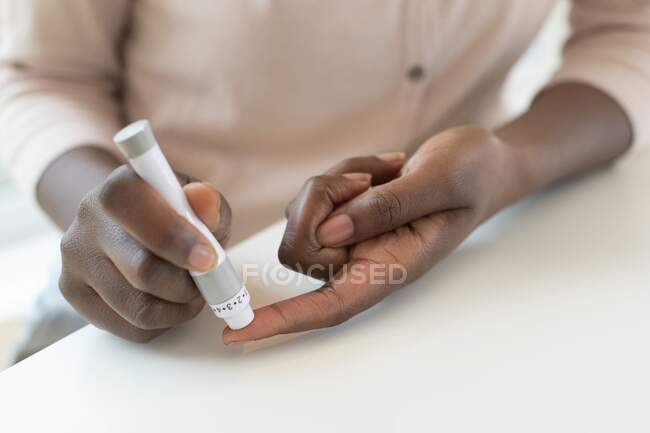 Frau nimmt mit Lanze Blutprobe mit Fingerstichen. — Stockfoto
