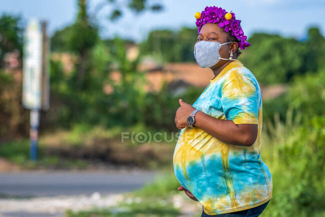 Беременная женщина в маске для лица. — стоковое фото