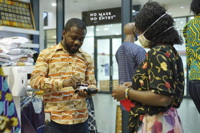 Homme traitant une transaction par carte dans un magasin. — Photo de stock